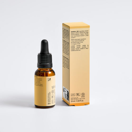 An amber glass dropper bottle with a black cap stands next to its matching tan cardboard box on a clean white background.